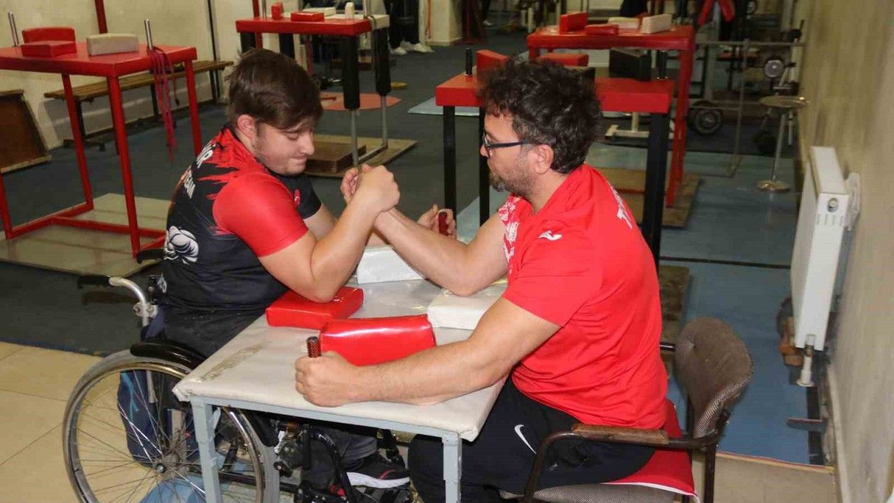 Aynı engele sahip olan öğrencisi ile bilek güreşi yapıyor