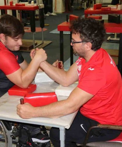 Aynı engele sahip olan öğrencisi ile bilek güreşi yapıyor