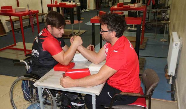 Aynı engele sahip olan öğrencisi ile bilek güreşi yapıyor