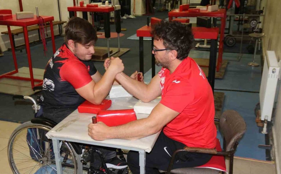 Aynı engele sahip olan öğrencisi ile bilek güreşi yapıyor