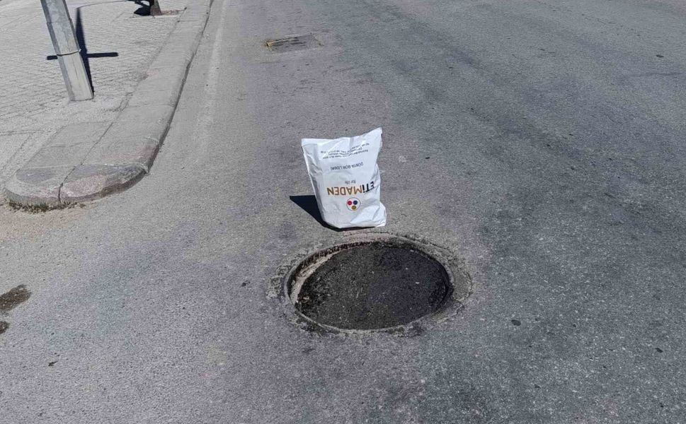 Çöken rögar kapağını gören vatandaş poşetle önlem aldı